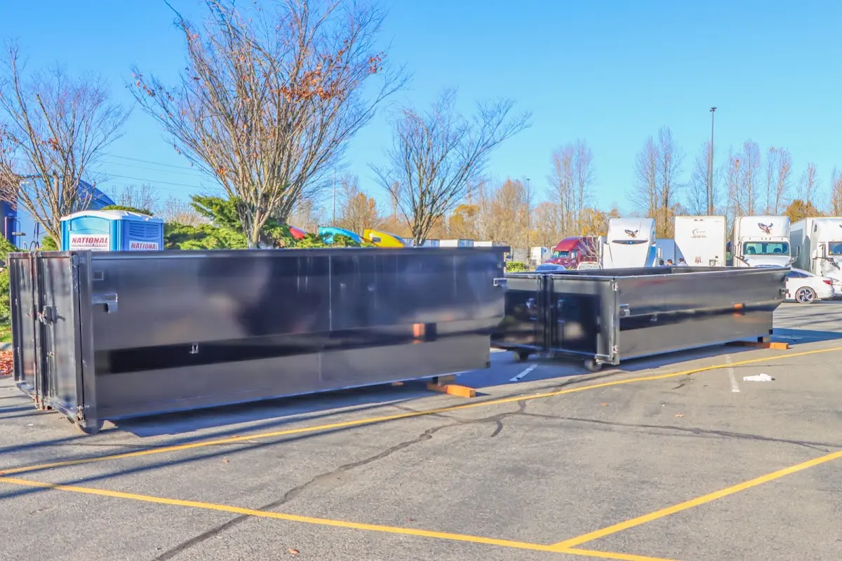 Professional dumpster rental service with roll-off container on residential driveway in Fall River